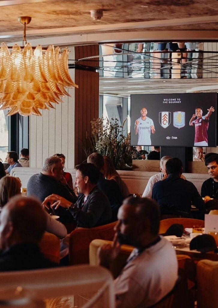 People sat round tables in hospitality lounge