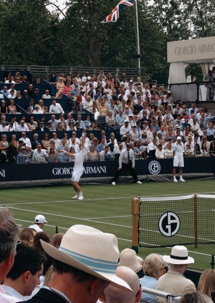 tennis player taking a serve with crowd in background