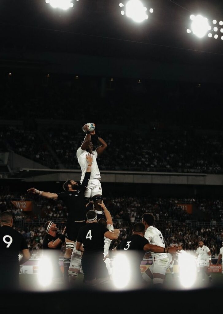 Rugby player lifted in the air catching ball