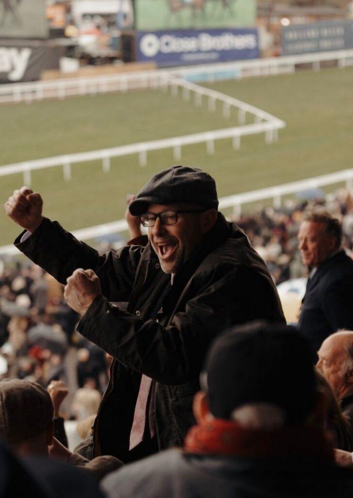 man celebrating with racecourse in background